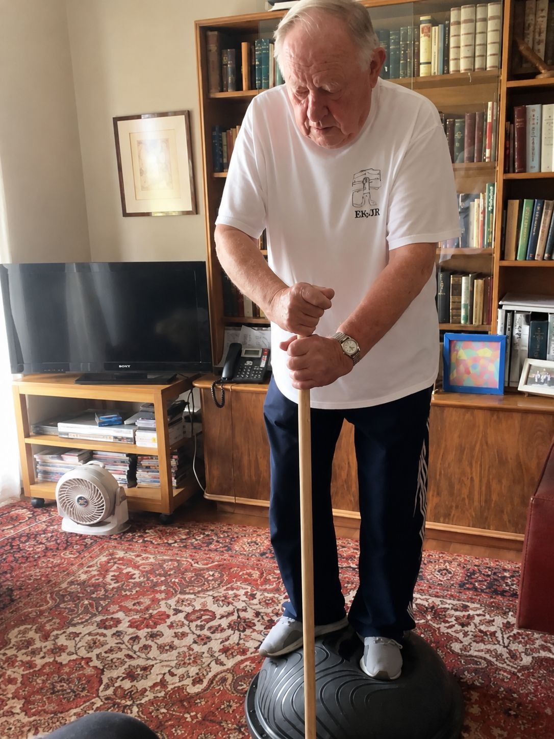 Adulto mayor practicando equilibrio sobre base inestable en su hogar