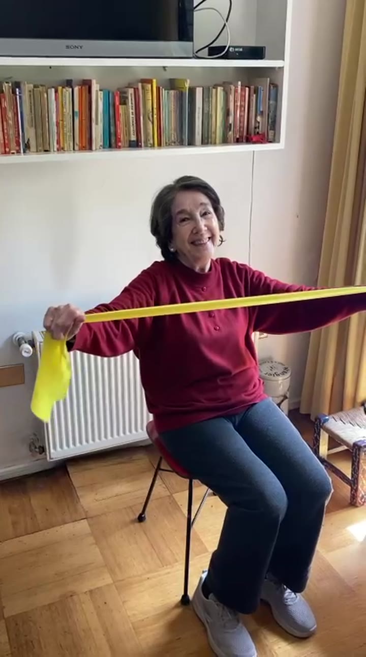 Ejercicio funcional sentado durante una sesión de rehabilitación para adultos mayores