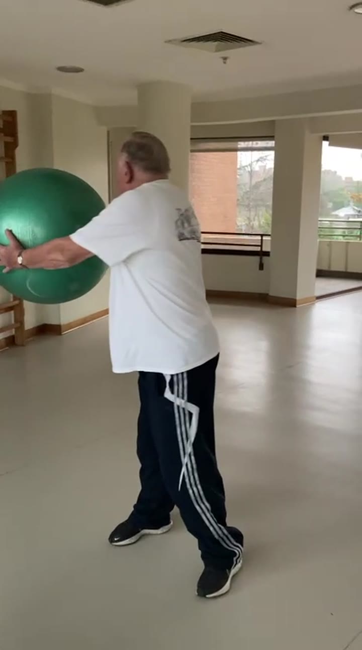 Trabajo funcional con balón durante una sesión de rehabilitación para adultos mayores